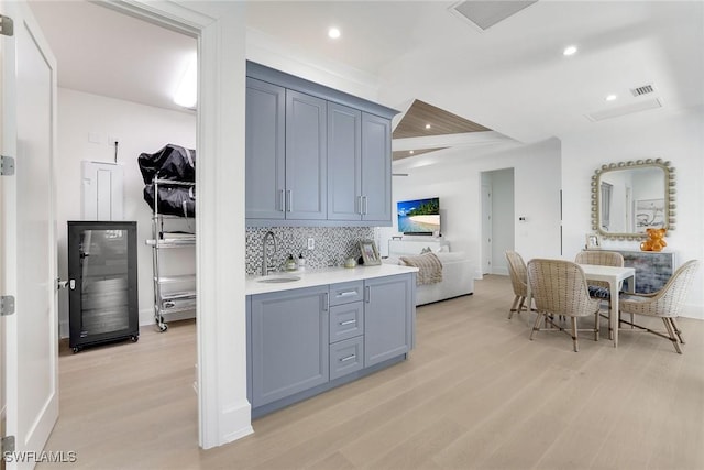 1761 Ludlow Rd, Marco Island, FL 34145 - kitchen with a sink, light wood-style floors, decorative backsplash, light countertops, and recessed lighting