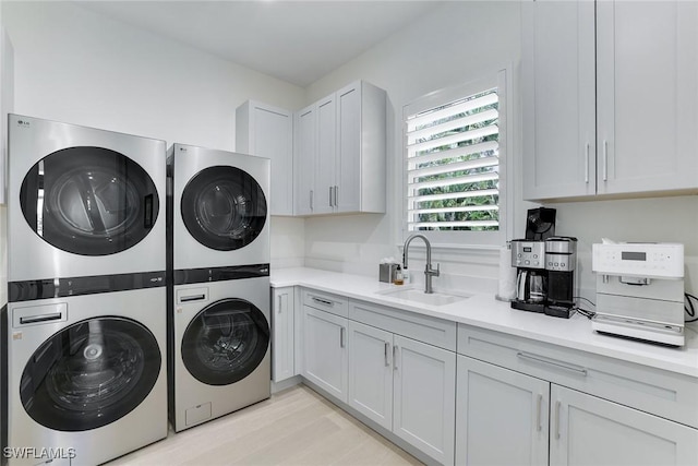 1761 Ludlow Rd, Marco Island, FL 34145 - washroom featuring stacked washer / drying machine, light wood-style floors, washer and dryer, and cabinet space