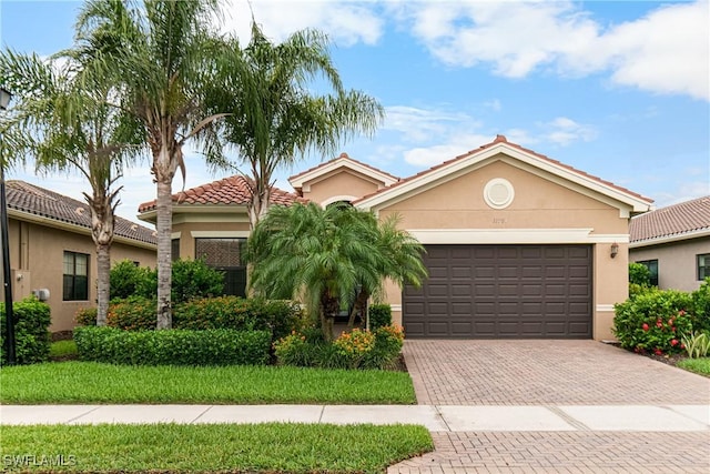 11704 Stonecreek Cir, Fort Myers, FL 33913 - view of front of home with stucco siding, decorative driveway, a garage, and a tiled roof