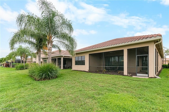 11704 Stonecreek Cir, Fort Myers, FL 33913 - back of property with a lawn, a sunroom, a tiled roof, and stucco siding