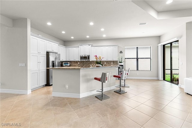 11704 Stonecreek Cir, Fort Myers, FL 33913 - kitchen with stainless steel appliances, white cabinets, a kitchen breakfast bar, recessed lighting, and tasteful backsplash