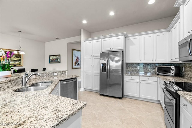 11704 Stonecreek Cir, Fort Myers, FL 33913 - kitchen featuring stainless steel appliances, a sink, white cabinetry, tasteful backsplash, and pendant lighting