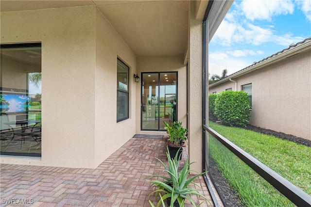 11704 Stonecreek Cir, Fort Myers, FL 33913 - view of exterior entry with stucco siding and a balcony