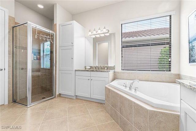 11704 Stonecreek Cir, Fort Myers, FL 33913 - bathroom with vanity, a garden tub, a stall shower, and tile patterned flooring