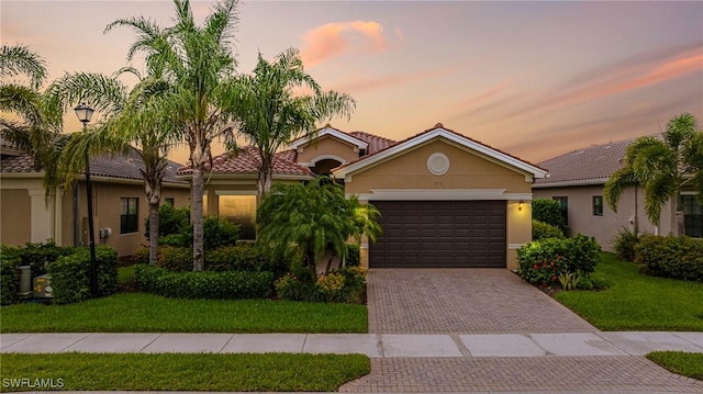 11704 Stonecreek Cir, Fort Myers, FL 33913 - view of front of home featuring an attached garage, stucco siding, decorative driveway, a front yard, and a tile roof