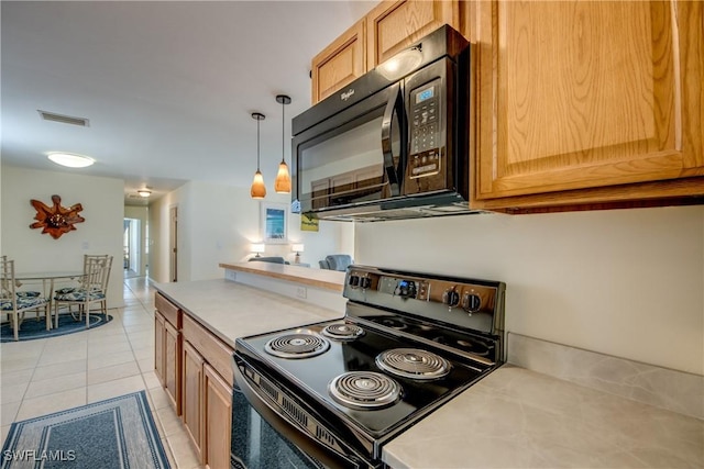 4149 Shellcrest Rd, Saint James City, FL 33956 - kitchen featuring black appliances, light countertops, light tile patterned floors, and hanging light fixtures