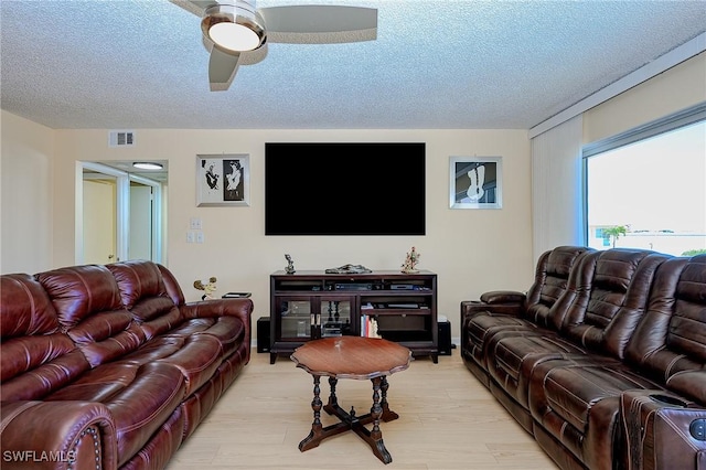 1100 8th Ave S Unit 309C, Naples, FL 34102 - living room with light wood finished floors, a textured ceiling, and a ceiling fan