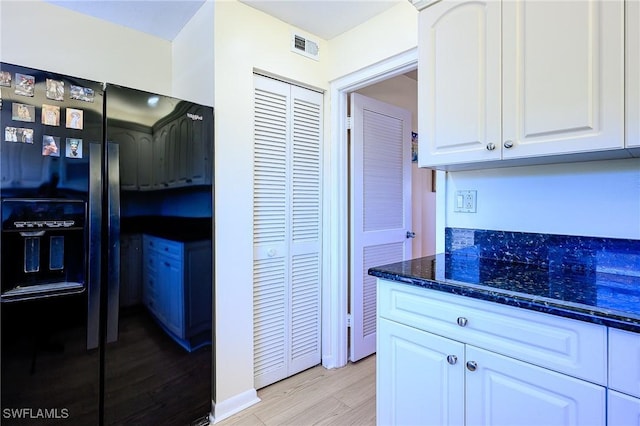 1100 8th Ave S Unit 309C, Naples, FL 34102 - kitchen featuring black fridge with ice dispenser, white cabinets, light wood-type flooring, and dark stone countertops