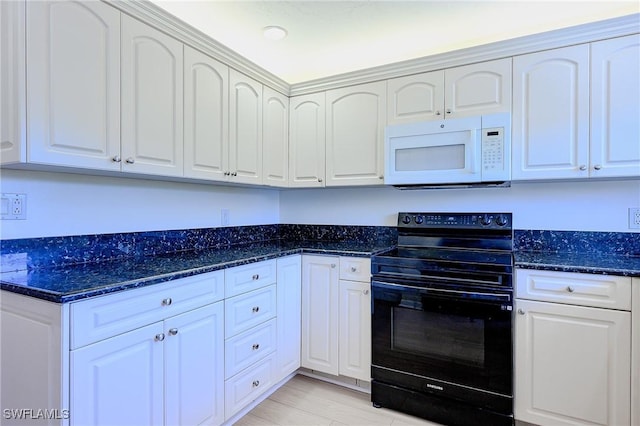 1100 8th Ave S Unit 309C, Naples, FL 34102 - kitchen featuring white microwave, black / electric stove, dark stone counters, white cabinets, and light wood-style floors