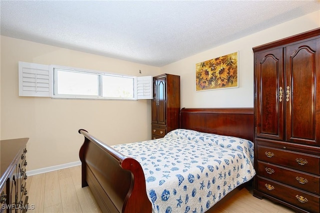 1100 8th Ave S Unit 309C, Naples, FL 34102 - bedroom featuring light wood finished floors and a textured ceiling