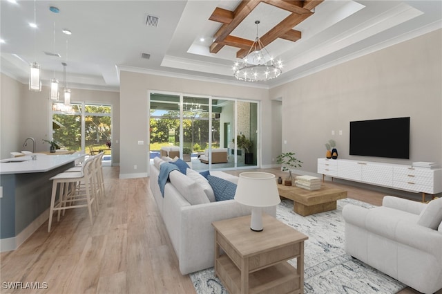 14302 Charthouse Cir, Naples, FL 34114 - living area featuring ornamental molding, a raised ceiling, light wood-style floors, baseboards, and a chandelier