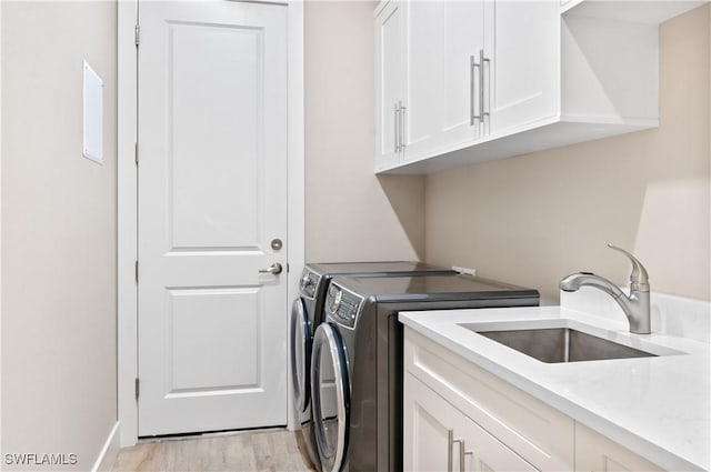 14302 Charthouse Cir, Naples, FL 34114 - laundry room featuring cabinet space, washing machine and dryer, and light wood-type flooring