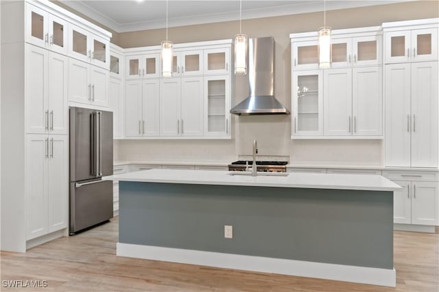 14302 Charthouse Cir, Naples, FL 34114 - kitchen featuring high end refrigerator, wall chimney range hood, light countertops, a center island with sink, and crown molding