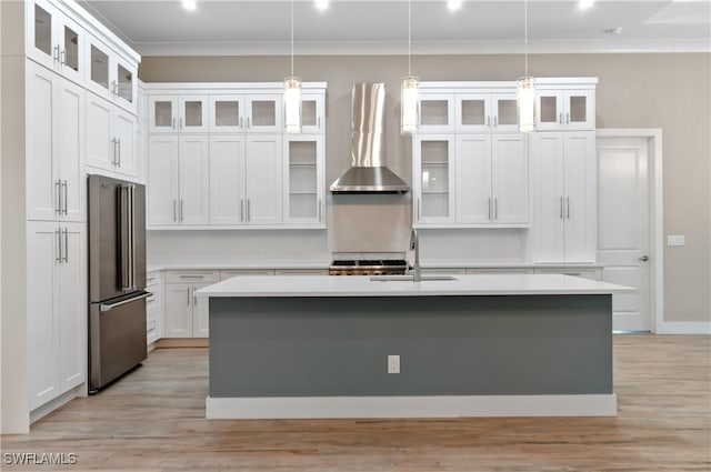 14302 Charthouse Cir, Naples, FL 34114 - kitchen with freestanding refrigerator, wall chimney exhaust hood, crown molding, a center island with sink, and light countertops