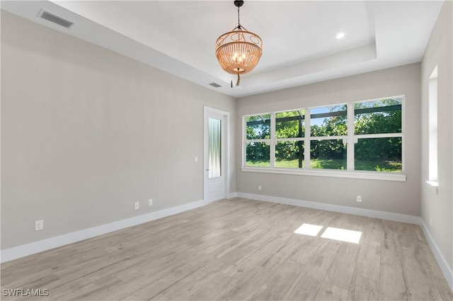 14302 Charthouse Cir, Naples, FL 34114 - empty room featuring a chandelier, light wood-type flooring, baseboards, and a raised ceiling