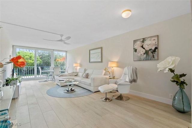 460 Broad Ave S Unit H460, Naples, FL 34102 - living room featuring wood finished floors, floor to ceiling windows, baseboards, and a ceiling fan