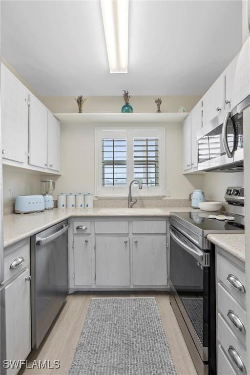460 Broad Ave S Unit H460, Naples, FL 34102 - kitchen featuring stainless steel appliances, a sink, light wood-style floors, and light countertops