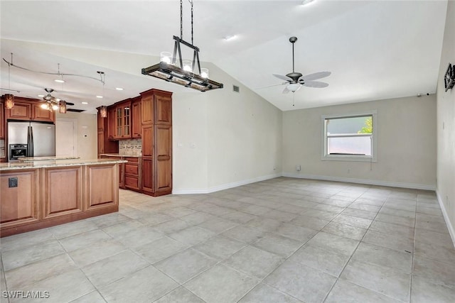5012 SW 8th Pl, Cape Coral, FL 33914 - kitchen with stainless steel fridge, a ceiling fan, lofted ceiling, light tile patterned floors, and light stone counters