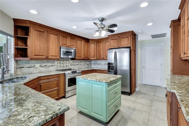 5012 SW 8th Pl, Cape Coral, FL 33914 - kitchen with stainless steel appliances, a sink, a ceiling fan, tasteful backsplash, and light stone counters
