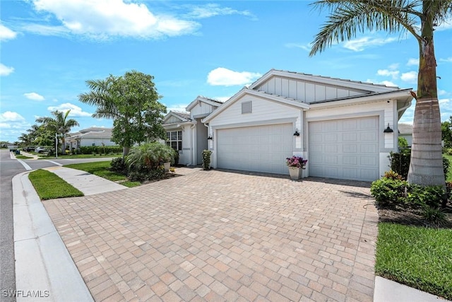28086 Captiva Shell Loop, Bonita Springs, FL 34135 - view of front facade with board and batten siding, decorative driveway, and a garage