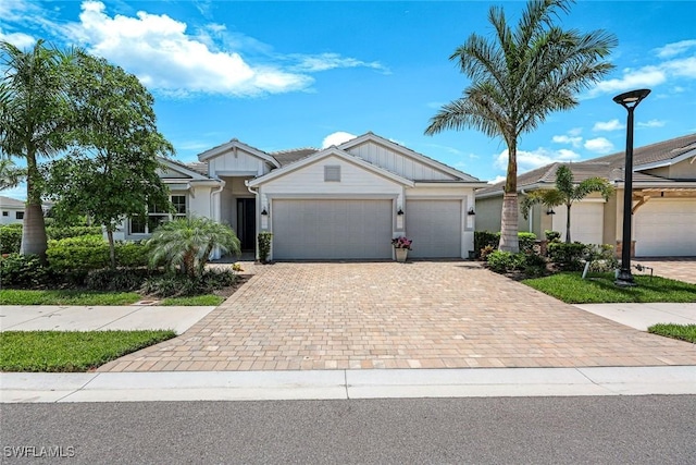 28086 Captiva Shell Loop, Bonita Springs, FL 34135 - ranch-style house featuring an attached garage, decorative driveway, and board and batten siding