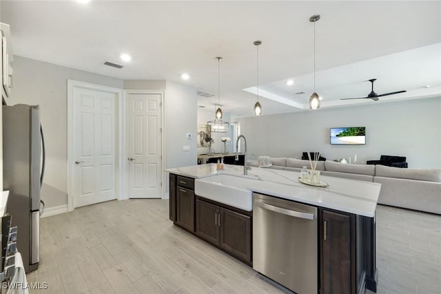 28086 Captiva Shell Loop, Bonita Springs, FL 34135 - kitchen with stainless steel appliances, dark brown cabinetry, open floor plan, a sink, and light wood finished floors