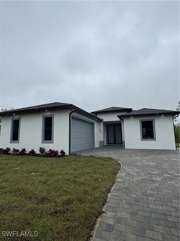 1403 Unice Ave N, Lehigh Acres, FL 33971 - view of front facade with stucco siding, a garage, and a front yard