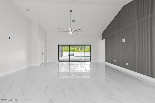 3613 39th St SW, Lehigh Acres, FL 33976 - spare room featuring marble finish floors, a ceiling fan, high vaulted ceiling, baseboards, and wood walls