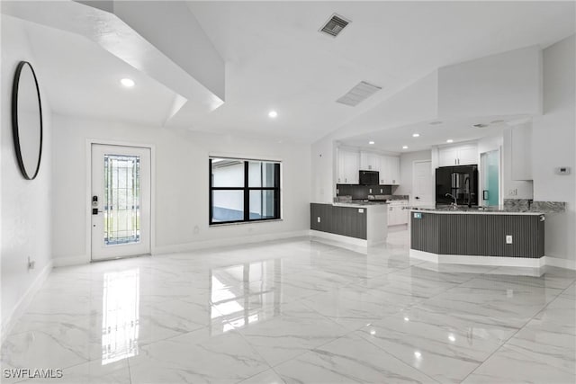 3613 39th St SW, Lehigh Acres, FL 33976 - unfurnished living room with light marble finish floors, baseboards, vaulted ceiling, and recessed lighting