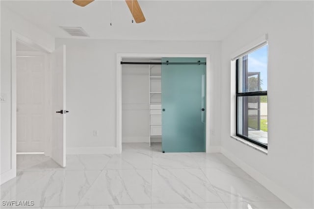 3613 39th St SW, Lehigh Acres, FL 33976 - unfurnished bedroom featuring marble look tiles, baseboards, a closet, and ceiling fan