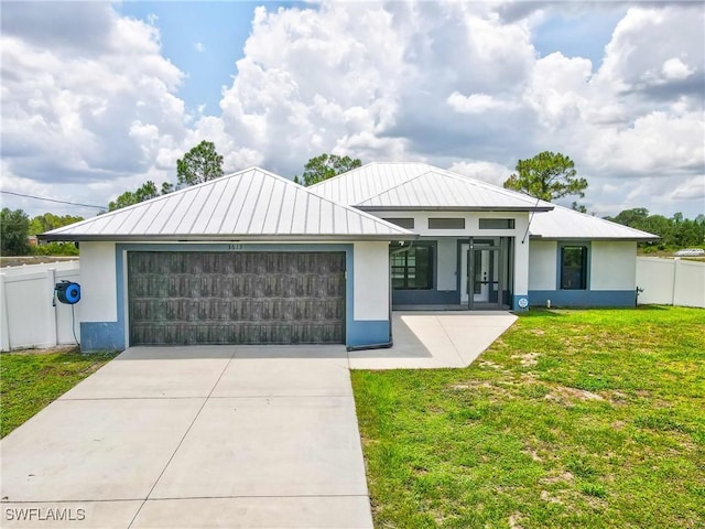 3613 39th St SW, Lehigh Acres, FL 33976 - view of front of home with stucco siding, an attached garage, a standing seam roof, driveway, and metal roof