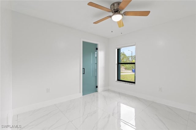 3613 39th St SW, Lehigh Acres, FL 33976 - spare room with baseboards, light marble finish flooring, and ceiling fan