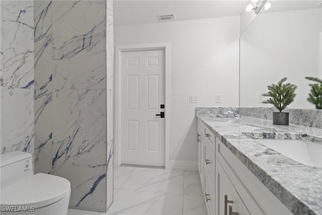 3613 39th St SW, Lehigh Acres, FL 33976 - bathroom with double vanity, marble look tiles, toilet, and baseboards