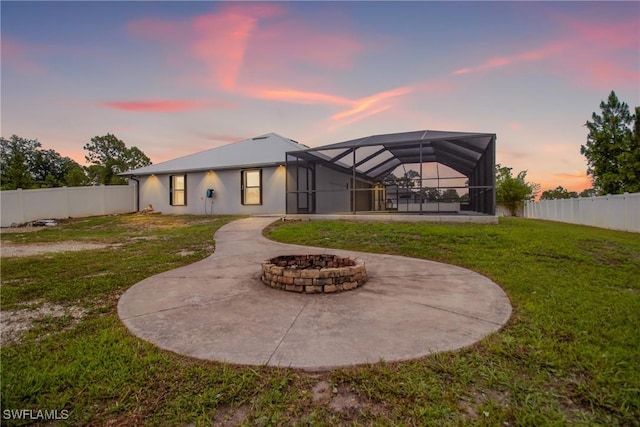 3613 39th St SW, Lehigh Acres, FL 33976 - back of house at dusk with a patio, a fire pit, and glass enclosure