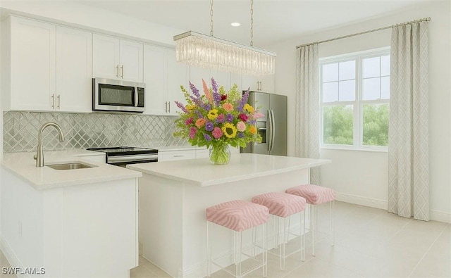 43981 Boardwalk Loop Unit 2225, Punta Gorda, FL 33982 - kitchen with appliances with stainless steel finishes, a sink, light countertops, backsplash, and white cabinetry