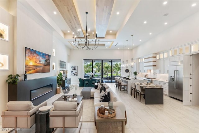 160 SW 52nd Ter, Cape Coral, FL 33914 - living room featuring a towering ceiling, a chandelier, recessed lighting, a glass covered fireplace, and a tray ceiling