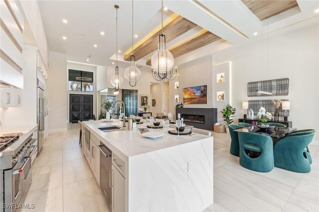 160 SW 52nd Ter, Cape Coral, FL 33914 - kitchen featuring a sink, stainless steel dishwasher, a spacious island, white cabinetry, and open floor plan