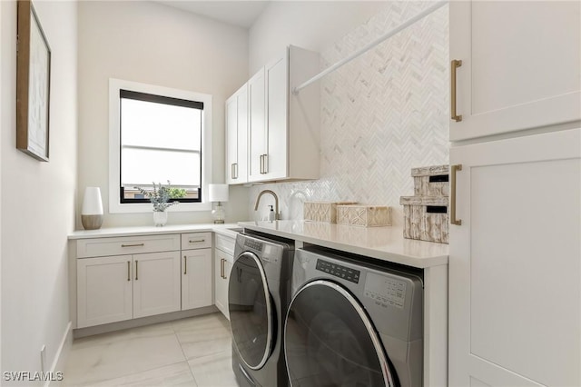 160 SW 52nd Ter, Cape Coral, FL 33914 - laundry room with washing machine and clothes dryer, cabinet space, light marble finish flooring, and baseboards
