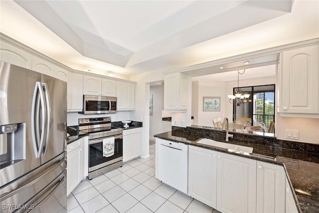 6500 Valen Way Unit A402, Naples, FL 34108 - kitchen with appliances with stainless steel finishes, a sink, a chandelier, light tile patterned flooring, and dark stone countertops