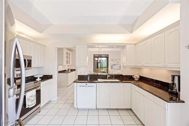 6500 Valen Way Unit A402, Naples, FL 34108 - kitchen featuring appliances with stainless steel finishes, a sink, light tile patterned floors, a peninsula, and white cabinets
