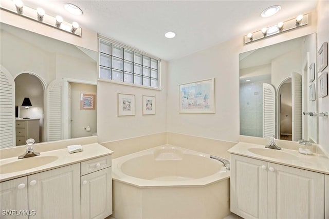 6500 Valen Way Unit A402, Naples, FL 34108 - bathroom featuring two vanities, a bath, a shower with door, and recessed lighting