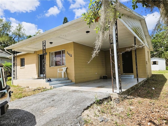 1112 Evanston St, Sebring, FL 33870 - rear view of house with asphalt driveway and a carport