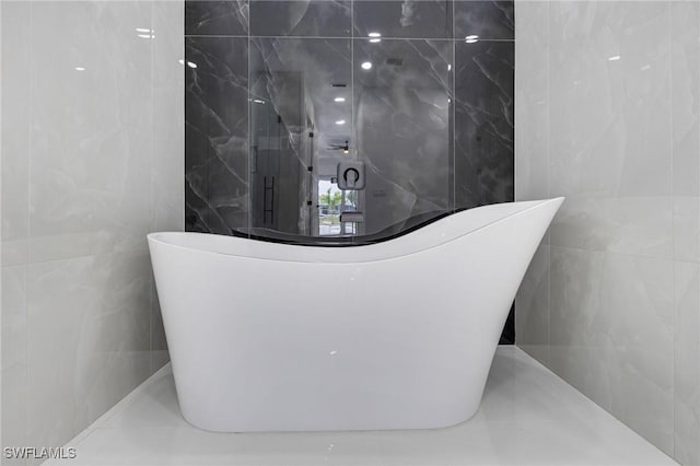 149 SE 21st St, Cape Coral, FL 33990 - bathroom featuring tile walls and a freestanding bath