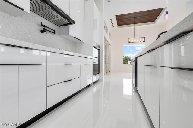 149 SE 21st St, Cape Coral, FL 33990 - kitchen featuring modern cabinets, white cabinetry, light tile patterned floors, decorative light fixtures, and light stone counters