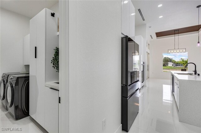 149 SE 21st St, Cape Coral, FL 33990 - washroom featuring washing machine and clothes dryer, recessed lighting, a chandelier, and light tile patterned flooring