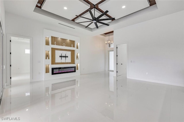 149 SE 21st St, Cape Coral, FL 33990 - unfurnished living room with a raised ceiling, a glass covered fireplace, tile patterned flooring, a chandelier, and recessed lighting