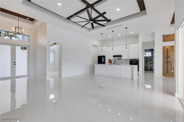 149 SE 21st St, Cape Coral, FL 33990 - unfurnished living room with a high ceiling, light tile patterned flooring, a chandelier, recessed lighting, and a sink