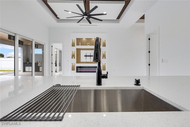 149 SE 21st St, Cape Coral, FL 33990 - kitchen view of a ceiling fan, a sink, and light stone countertops