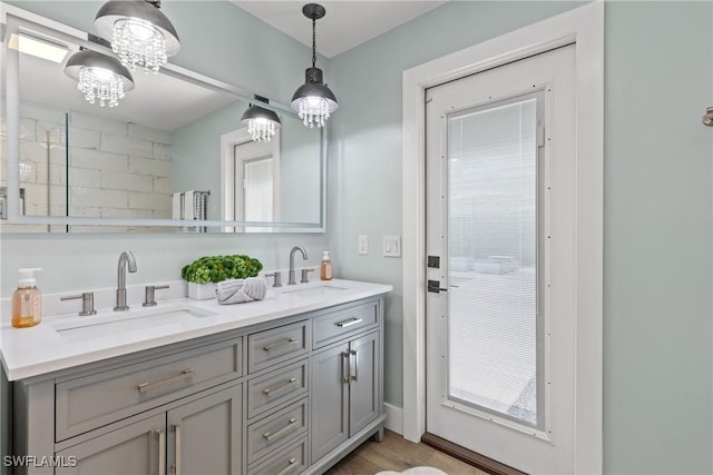 1020 SW 56th St, Cape Coral, FL 33914 - bathroom with double vanity, a chandelier, and wood finished floors