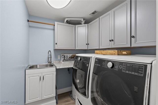 1020 SW 56th St, Cape Coral, FL 33914 - washroom with washing machine and clothes dryer, cabinet space, and light wood finished floors